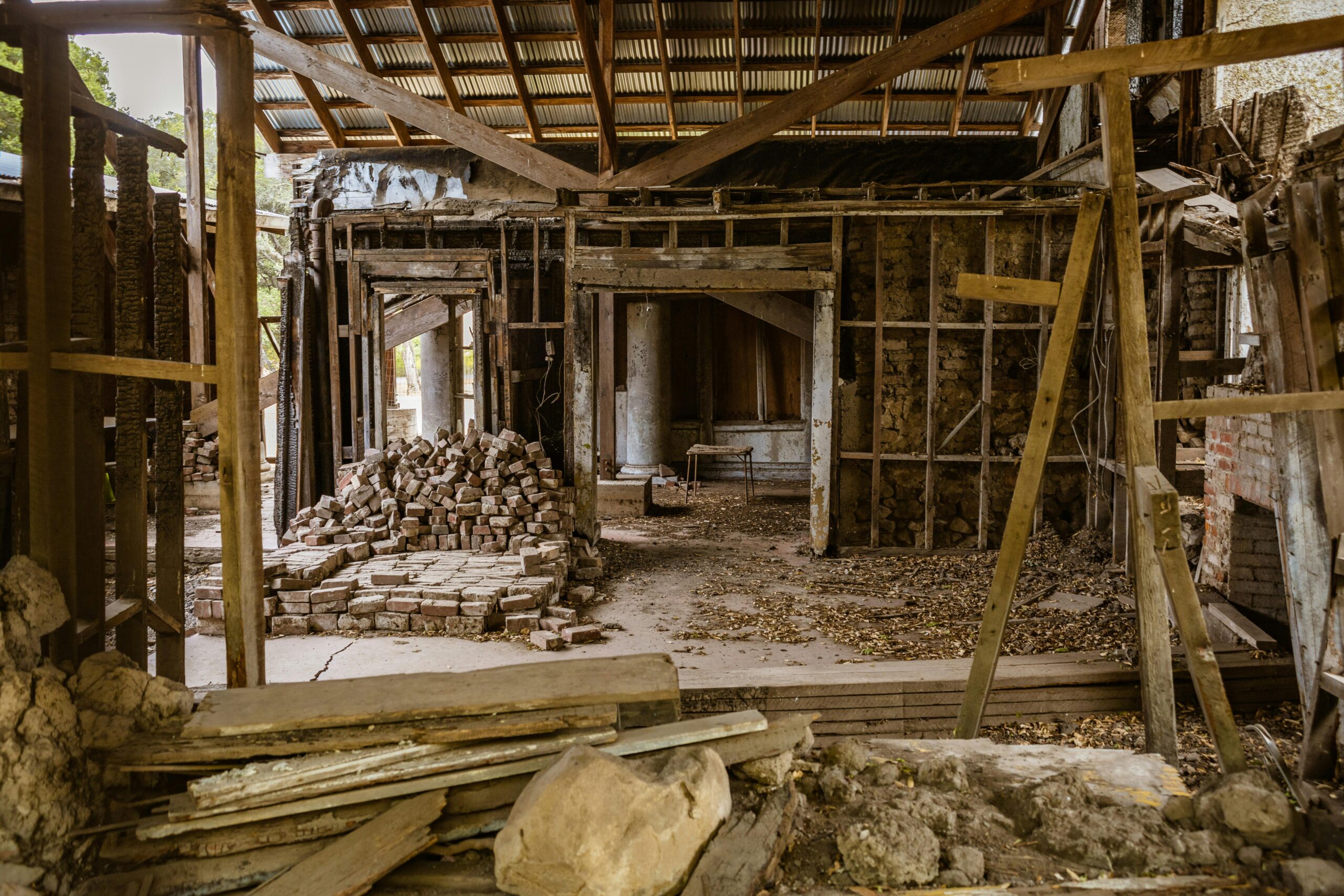 Detailed view of an abandoned workshop with stacked bricks and wooden beams.