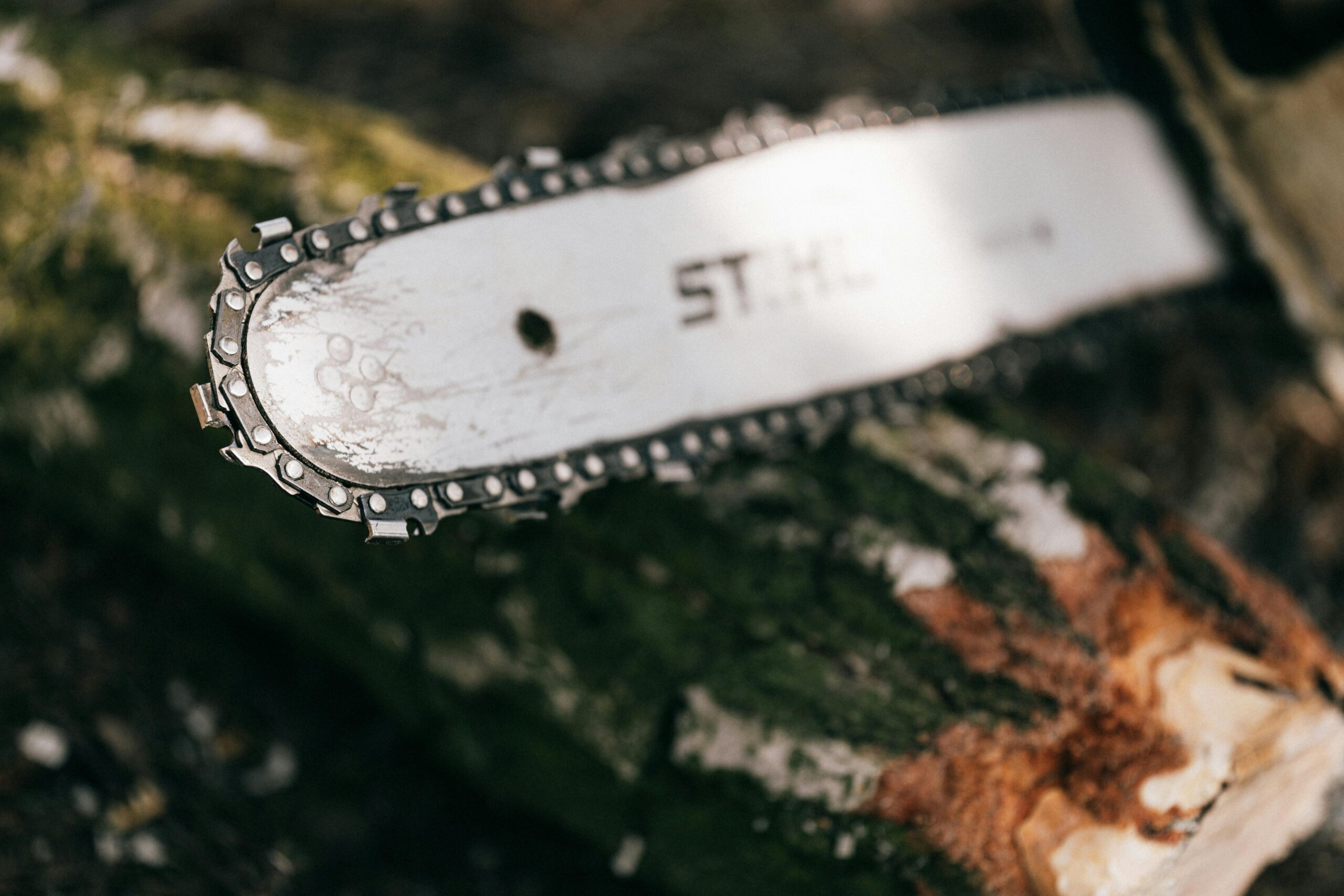 Detailed image of a chainsaw cutting into a log, showcasing metal blades and wood texture.