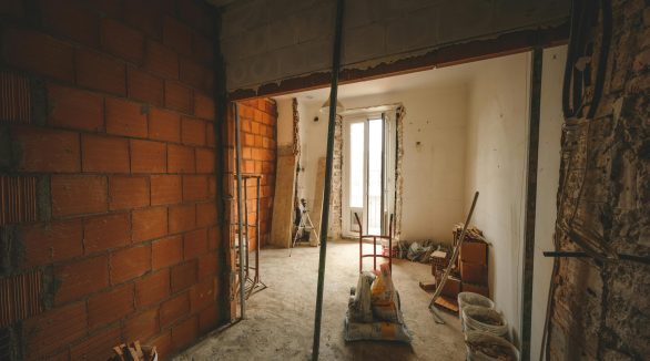 A partially renovated room with exposed brick walls and construction materials on site.
